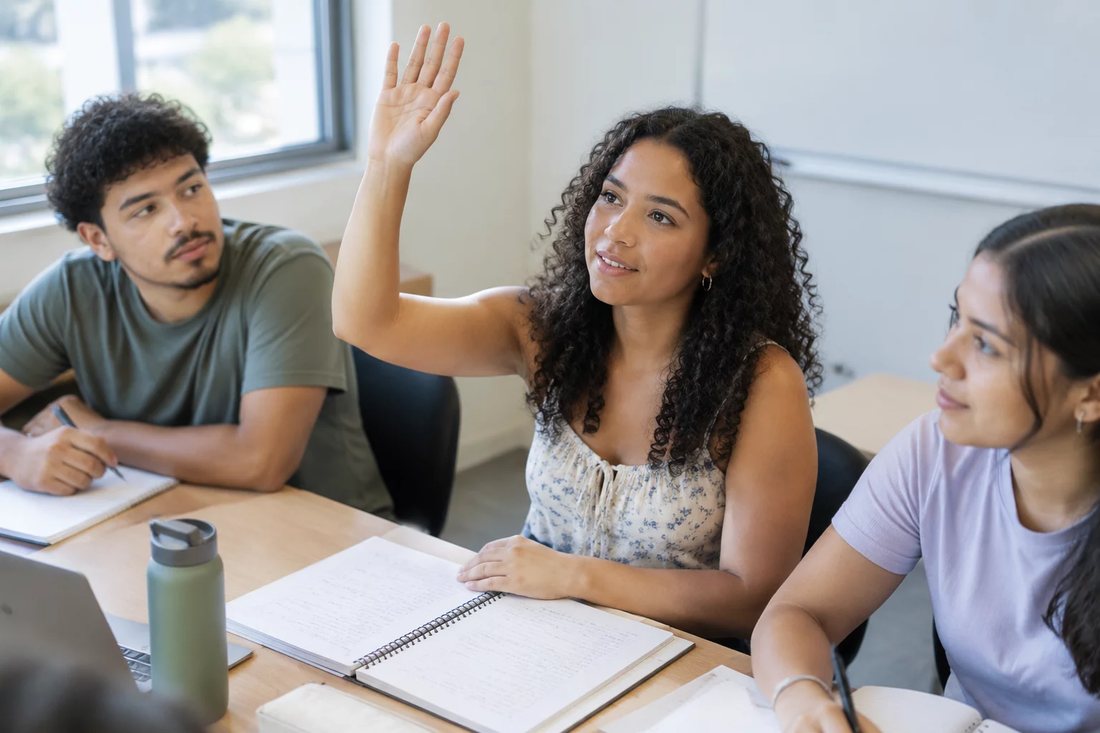 Facilitador em pé apontando para um argumento escrito no quadro durante a sessão